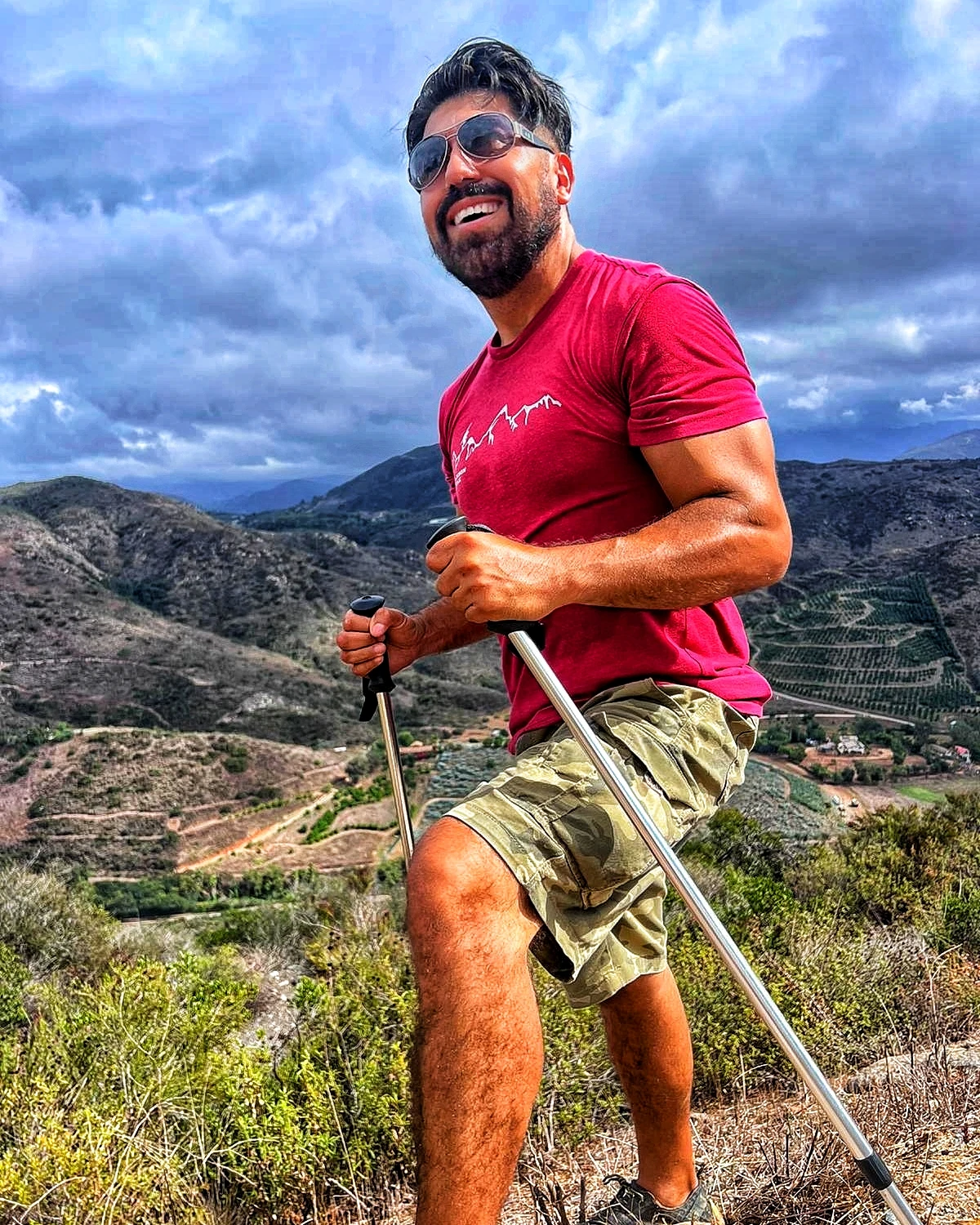 A hiker climbing beneath dramatic mountain clouds