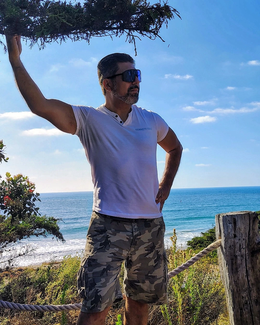 A person standing beside the ocean in natural light